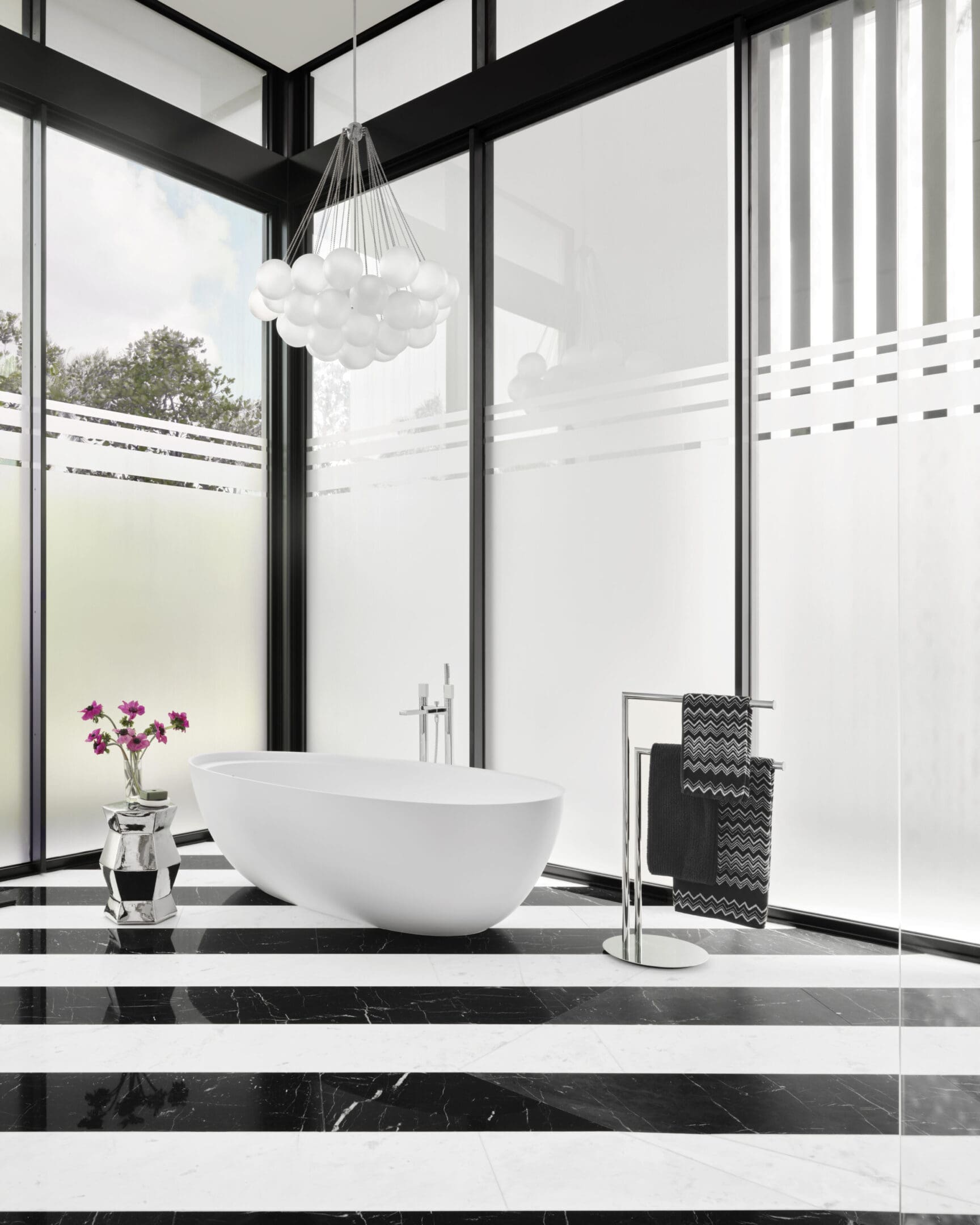 A bathroom with a large window and a white tub.