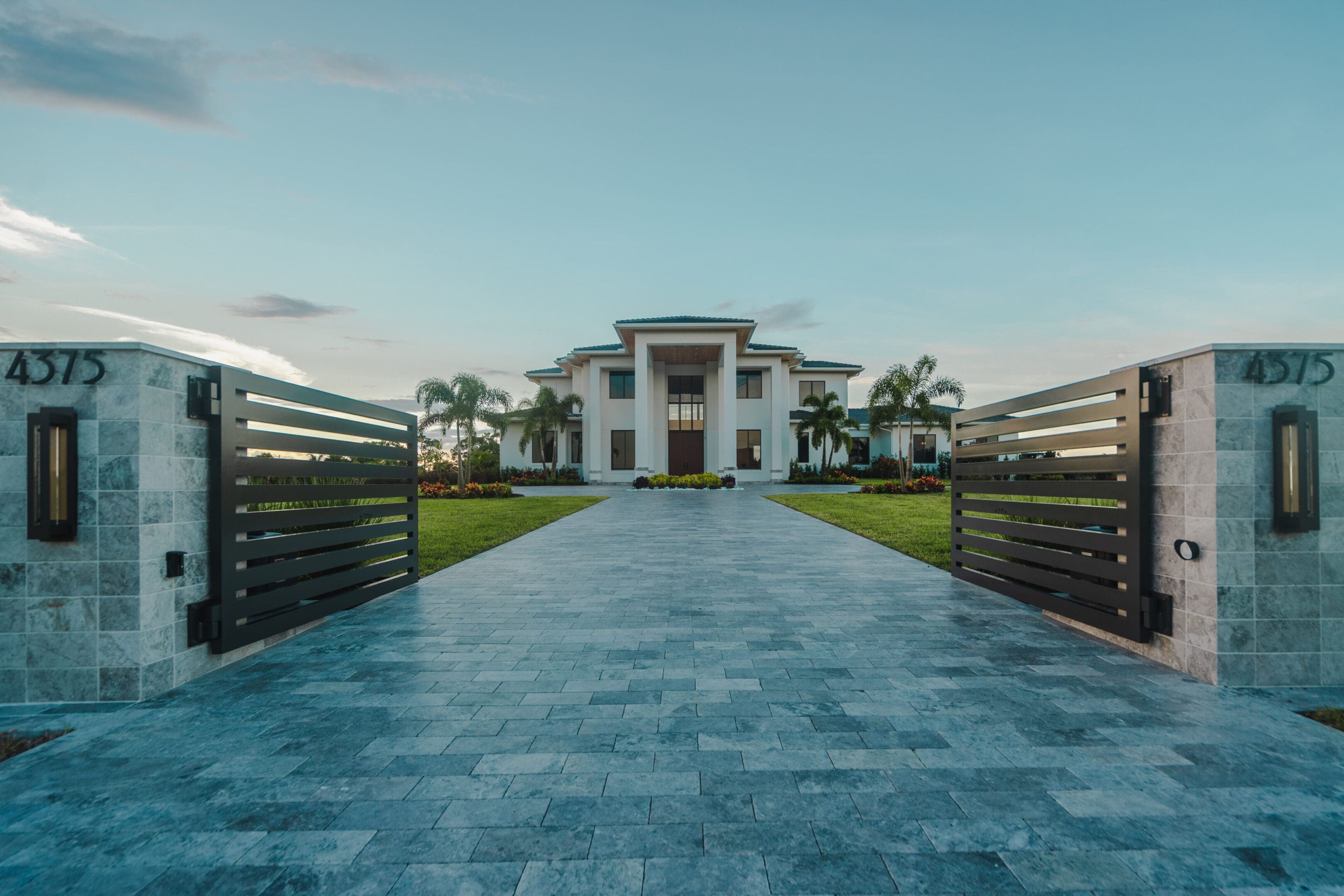 A large white house with a driveway leading to it.