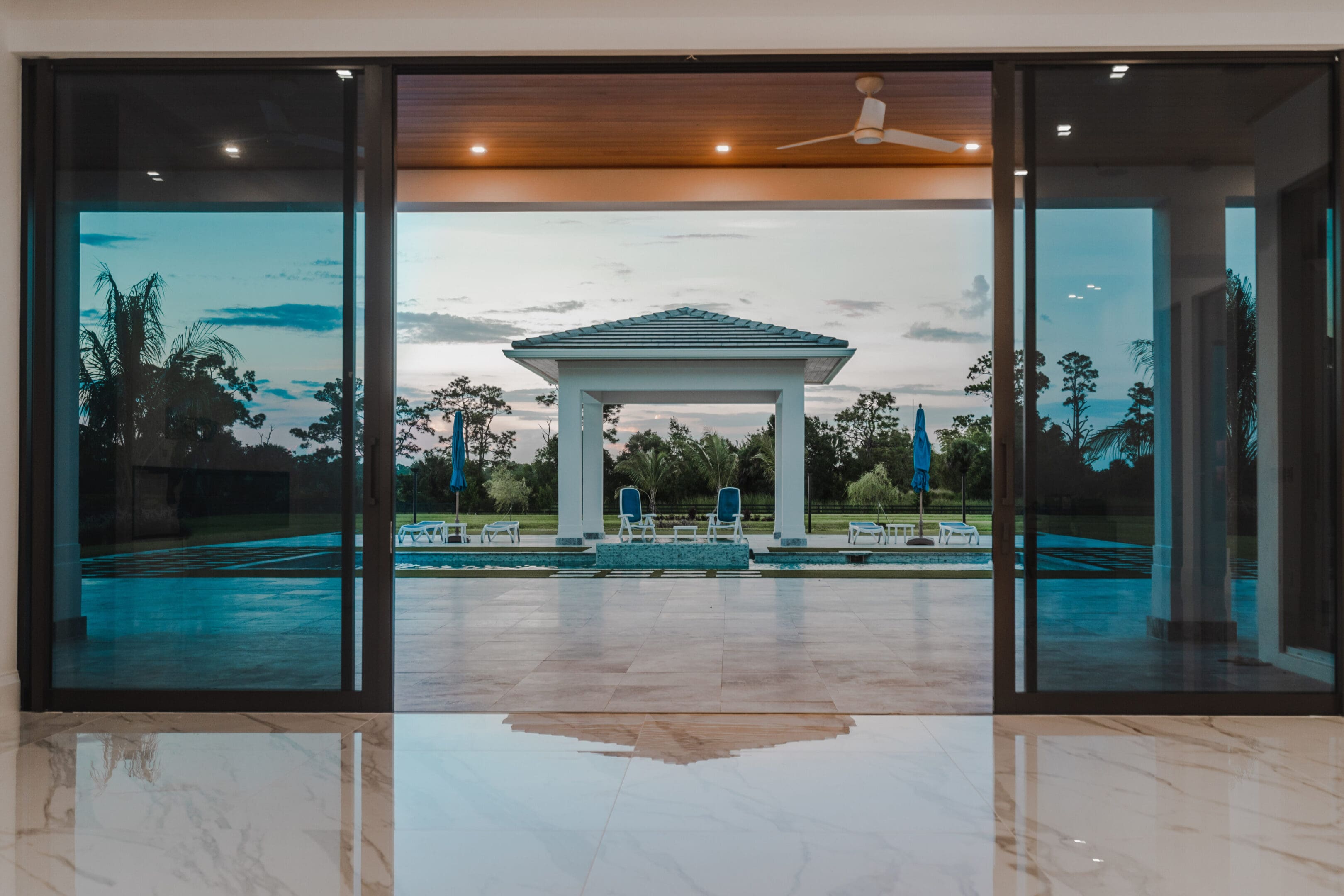 A large open door leading to an outdoor pool.