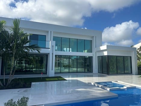 A large white building with a pool in front of it.